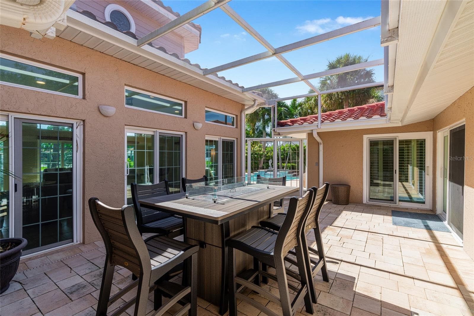 The fully screened courtyard lanai creates an inviting outdoor room at the center of the home, with space for dining and relaxing. - 5376 SHADOW LAWN DR, SARASOTA