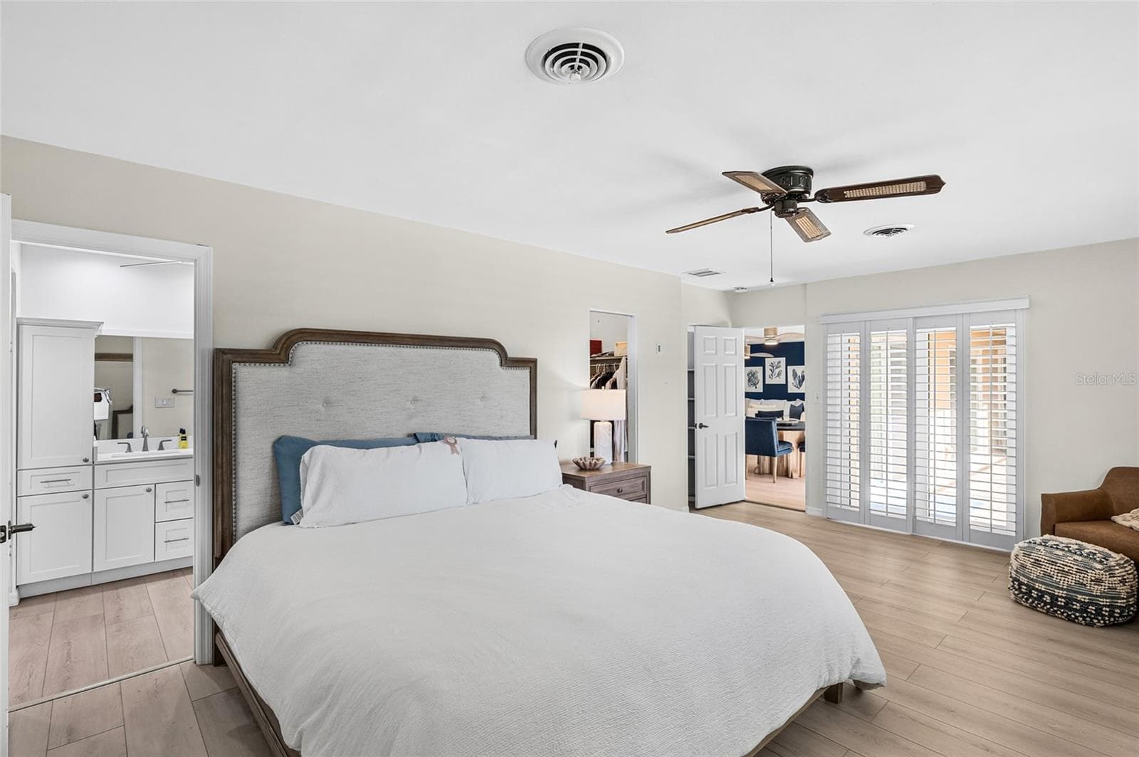The first floor primary suite offers comfortable proportions, direct courtyard access and two walk in closets. - 5376 SHADOW LAWN DR, SARASOTA