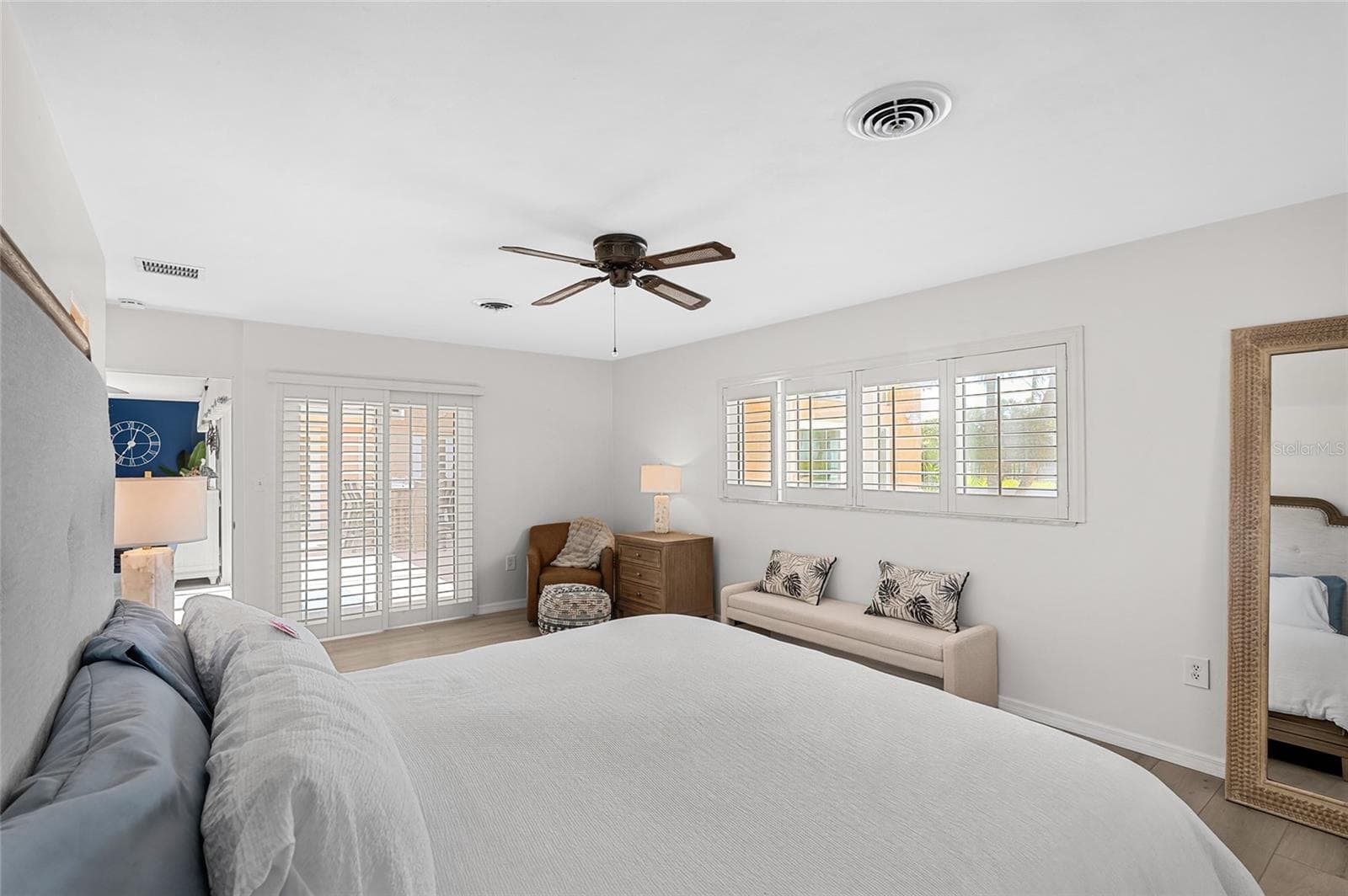 The first floor primary suite offers comfortable proportions, direct courtyard access and two walk in closets. - 5376 SHADOW LAWN DR, SARASOTA