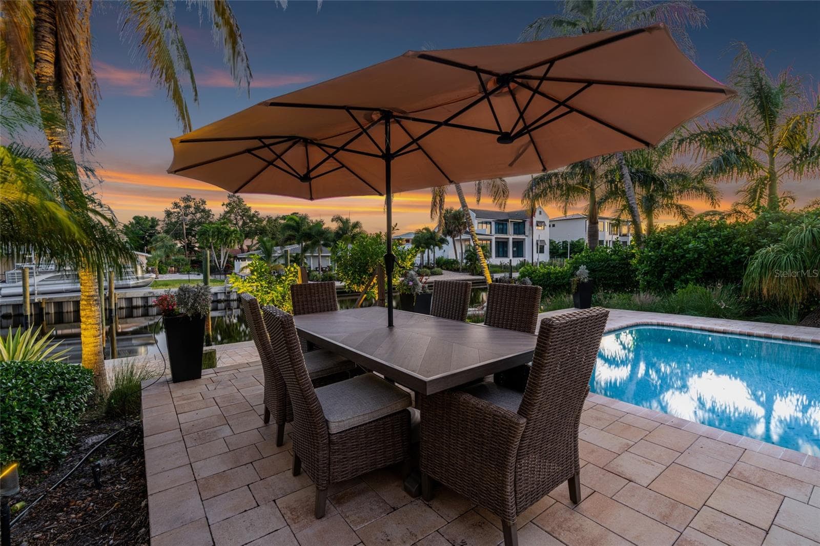 Outdoor Dining Twilight, extending the home's living and entertaining spaces outdoors. - 5376 SHADOW LAWN DR, SARASOTA