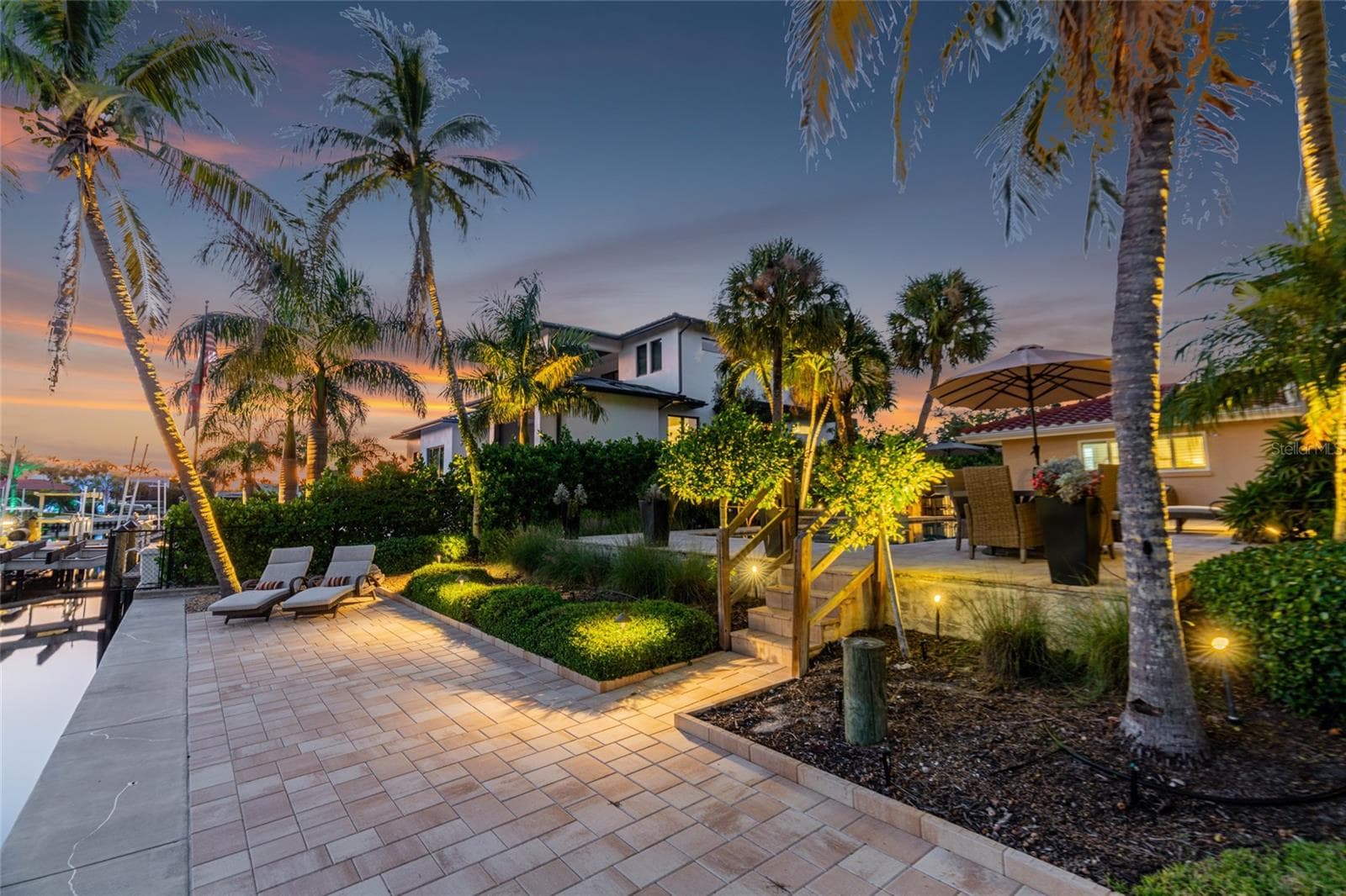 Waterfront Terrace Twilight, highlighting the connection to the water and Siesta Key lifestyle. - 5376 SHADOW LAWN DR, SARASOTA