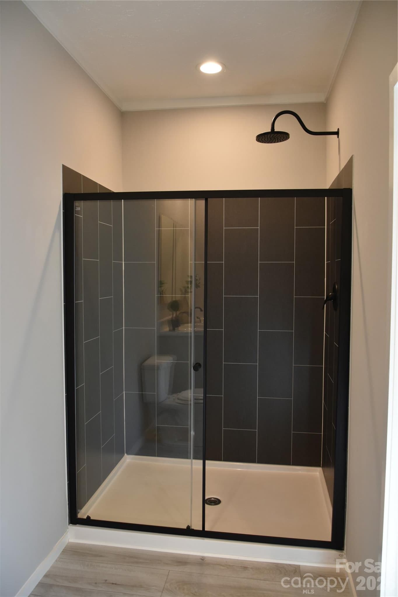 Primary bathroom-tiled shower panels and rain shower head - 105 Cottontail Lane, Statesville