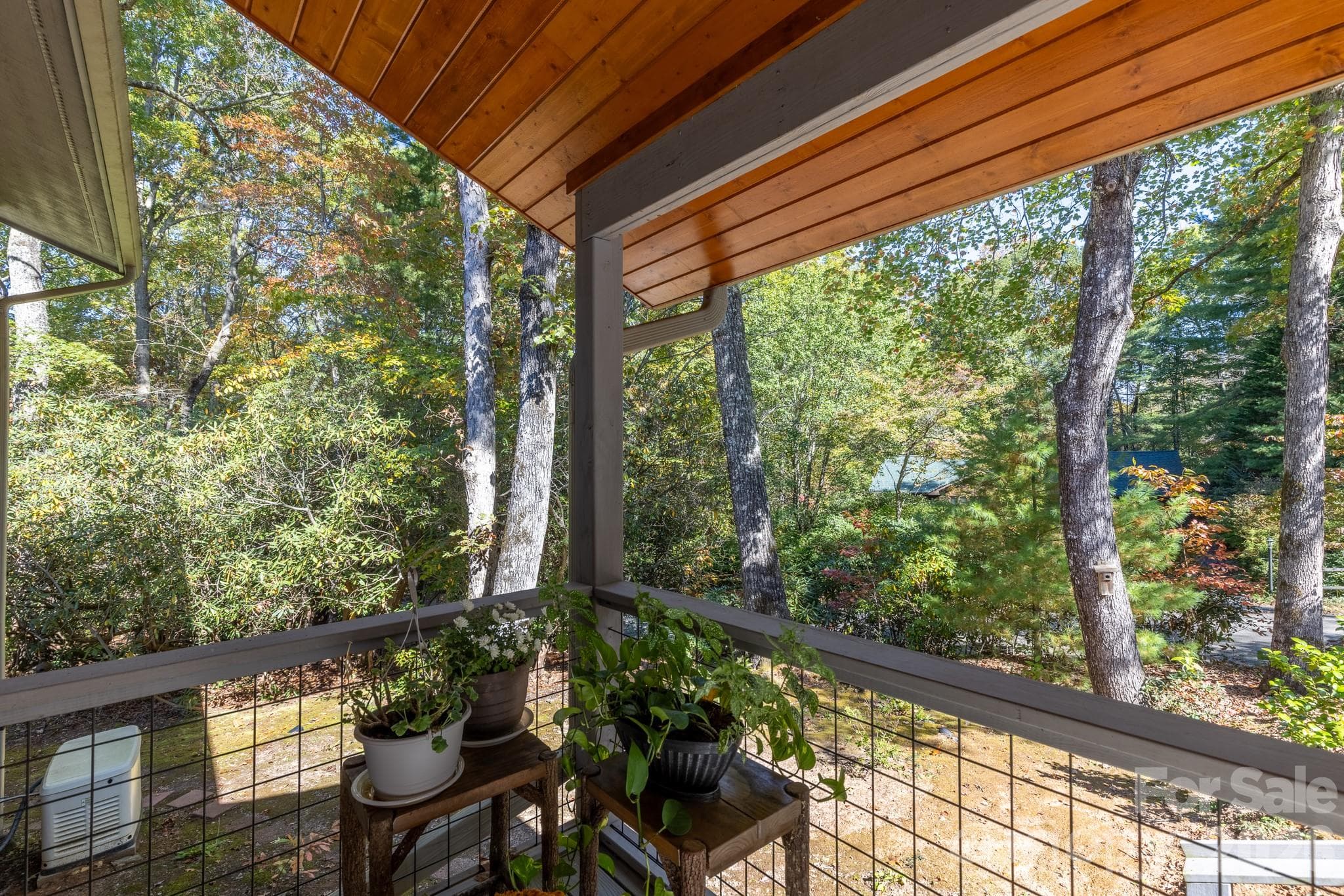 Charming covered entry porch with natural wood ceiling, decorative railings, and room for plants and outdoor seating. - 524 Three Mile Knob Road, Pisgah Forest