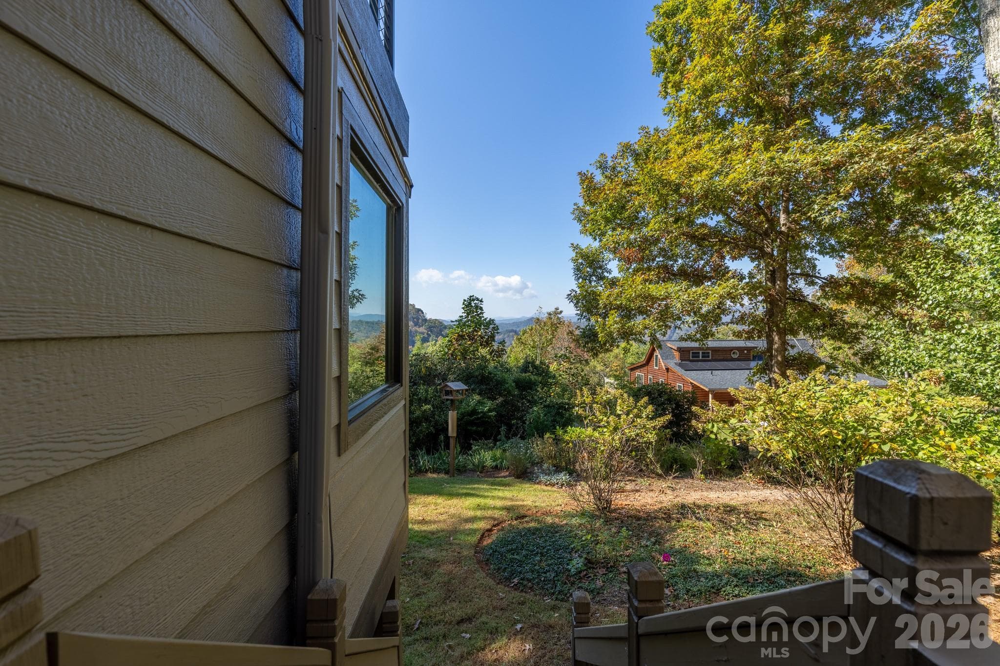 Beautifully landscaped grounds with a glimpse of the distant Blue Ridge Mountains. - 524 Three Mile Knob Road, Pisgah Forest