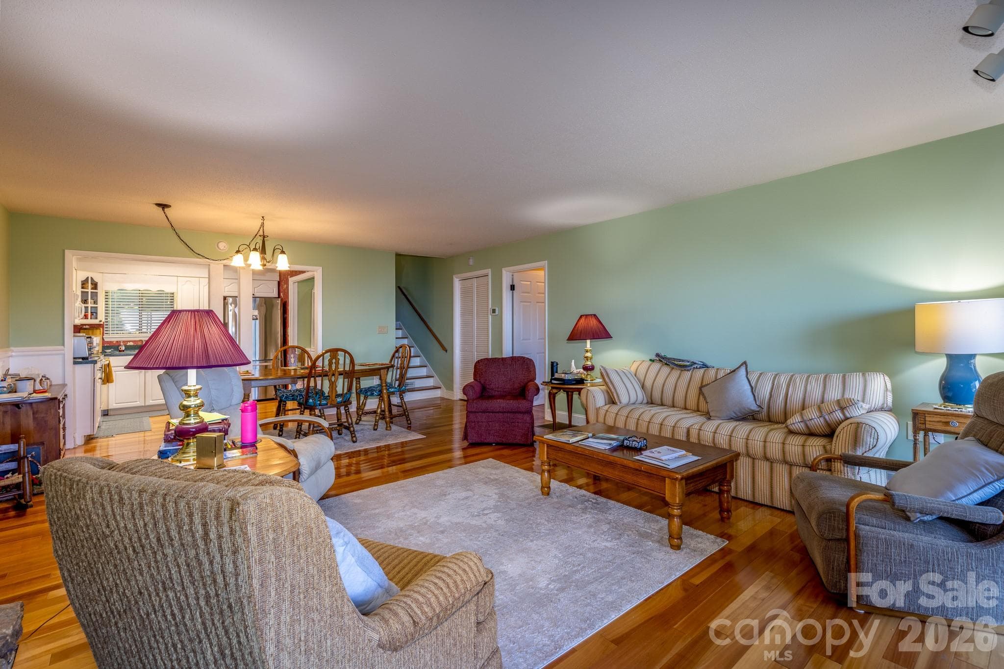 Spacious living and dining area with beautiful hardwood floors, abundant natural light, and an open, comfortable layout. - 524 Three Mile Knob Road, Pisgah Forest