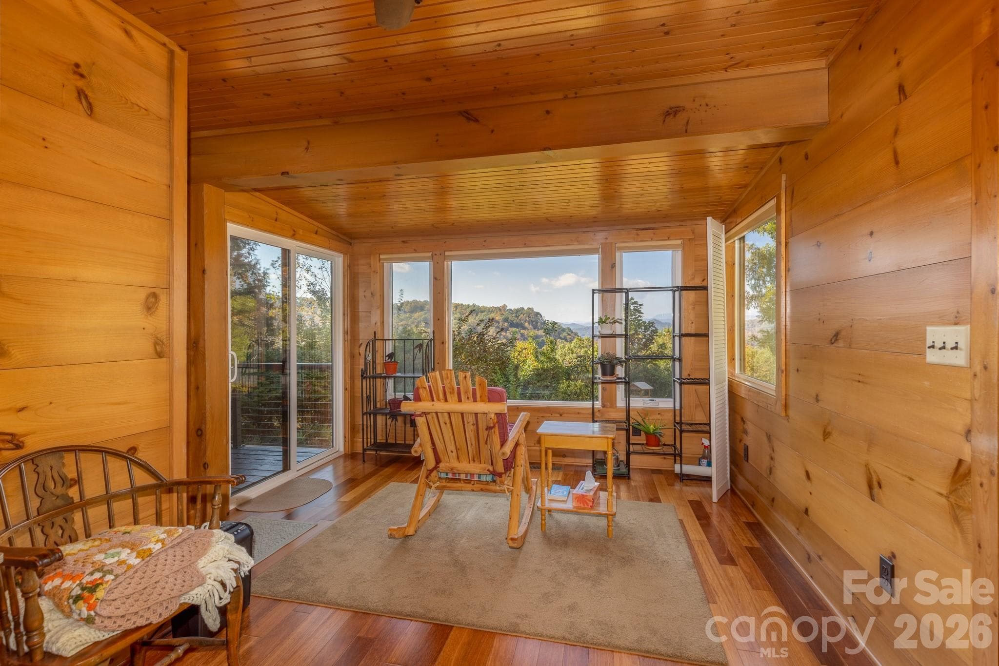 Exceptional sunroom surrounded by windows showcasing gorgeous long-range mountain views. An ideal setting for morning coffee, reading, or simply enjoying the scenery. - 524 Three Mile Knob Road, Pisgah Forest