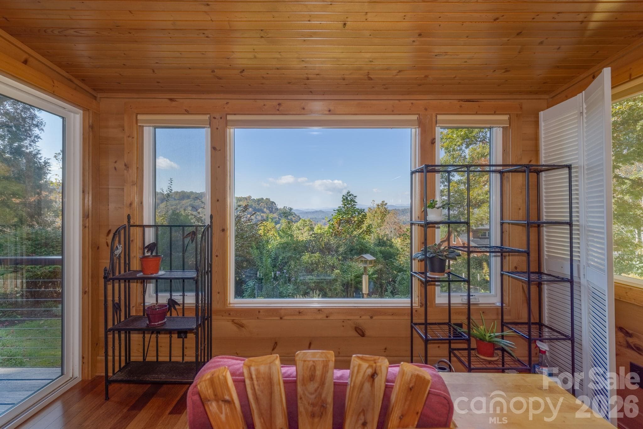 Spectacular mountain views framed by the sunroom's expansive windows, bringing the natural beauty of Western North Carolina indoors. - 524 Three Mile Knob Road, Pisgah Forest