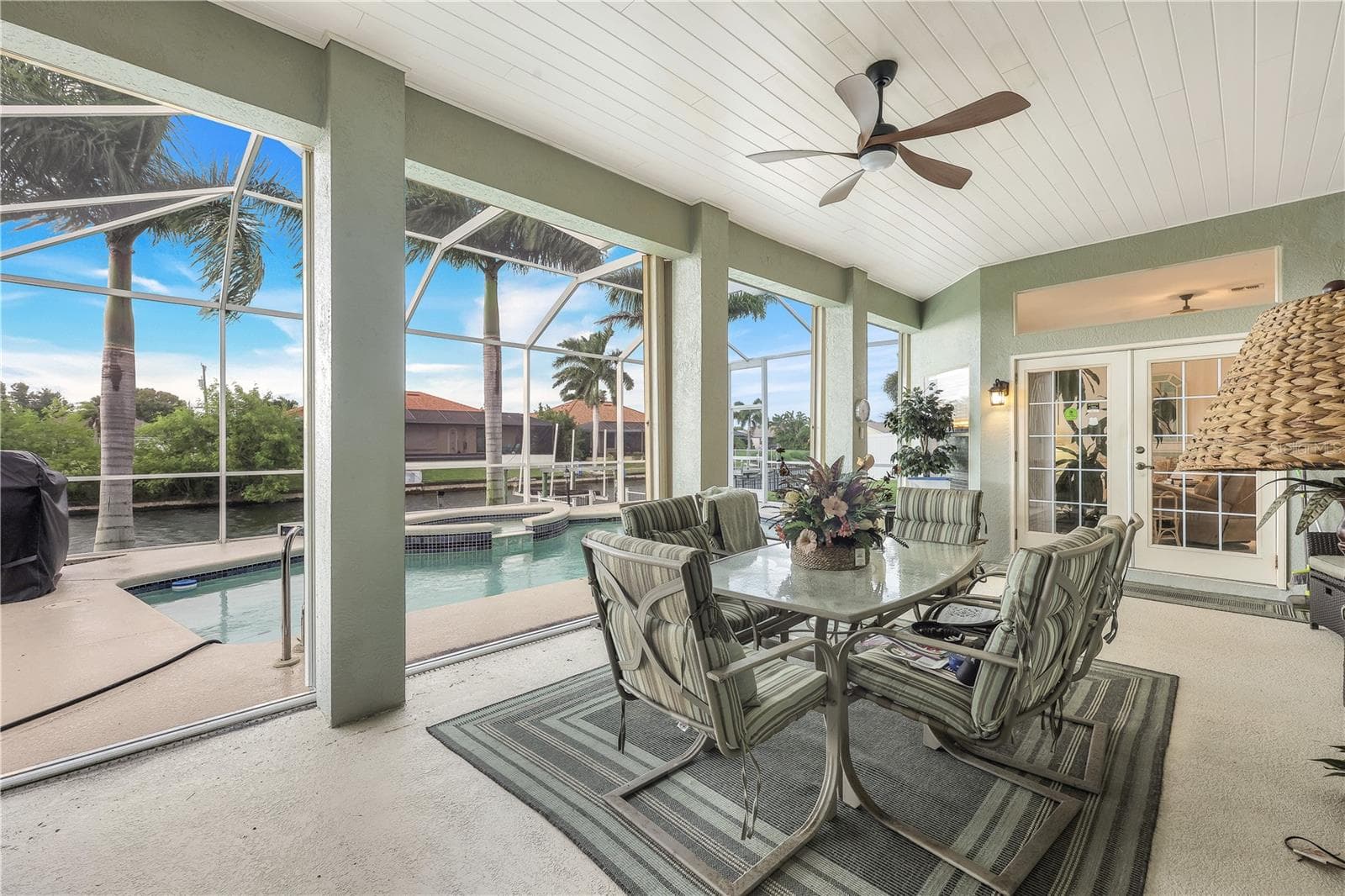 Huge lanai with French doors. View toward pool, backyard, dock and canal. - 305 SE 31ST ST, CAPE CORAL