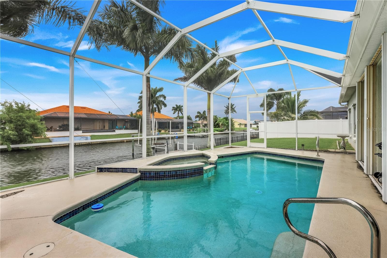 Pool and spa view toward the canal. - 305 SE 31ST ST, CAPE CORAL