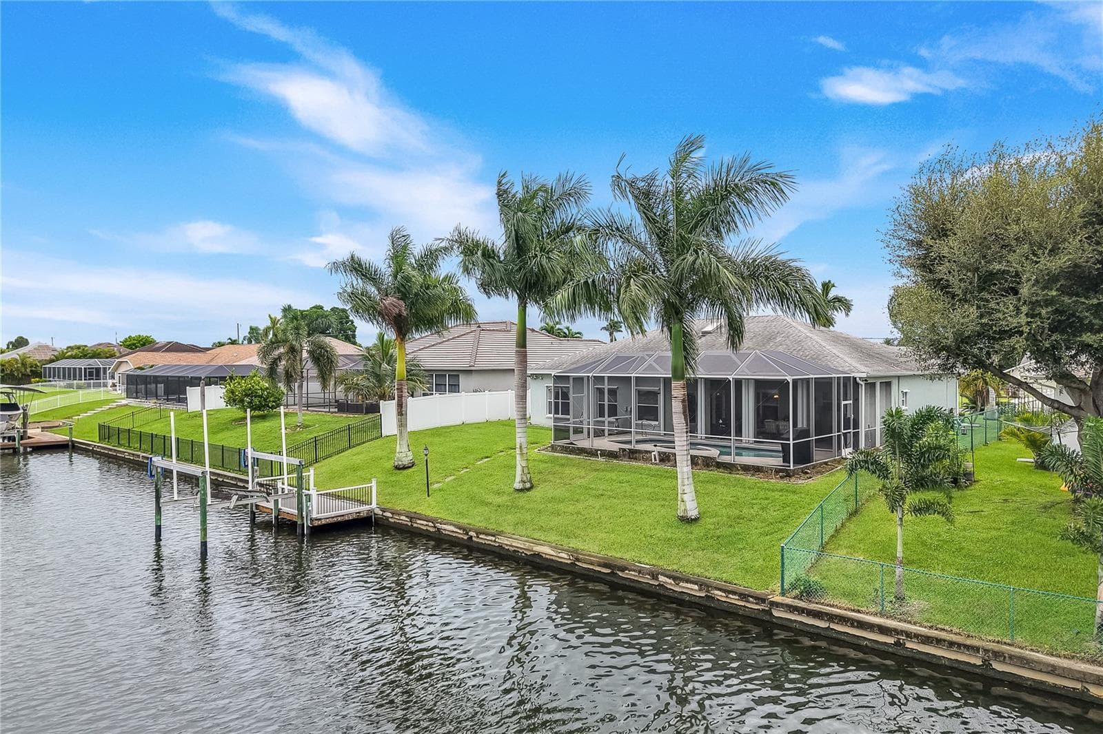 Lush back yard with royal palms, dock and lift. - 305 SE 31ST ST, CAPE CORAL