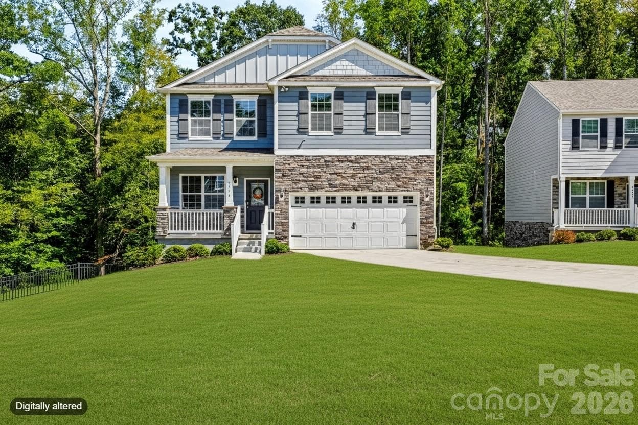 Front exterior of the home featuring Hardie board siding, a stone veneer façade, and a two-car garage with windows. - 3741 Stanley Creek Drive, Mount Holly