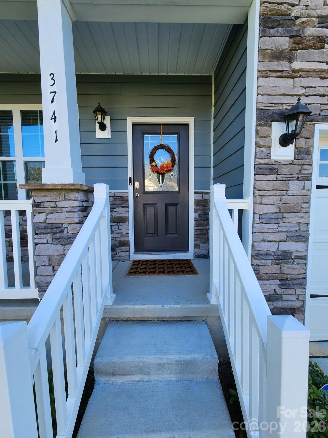 A welcoming set of steps leads to the front porch, featuring a decorative fiberglass front door complete with an elegant leaded glass insert. - 3741 Stanley Creek Drive, Mount Holly