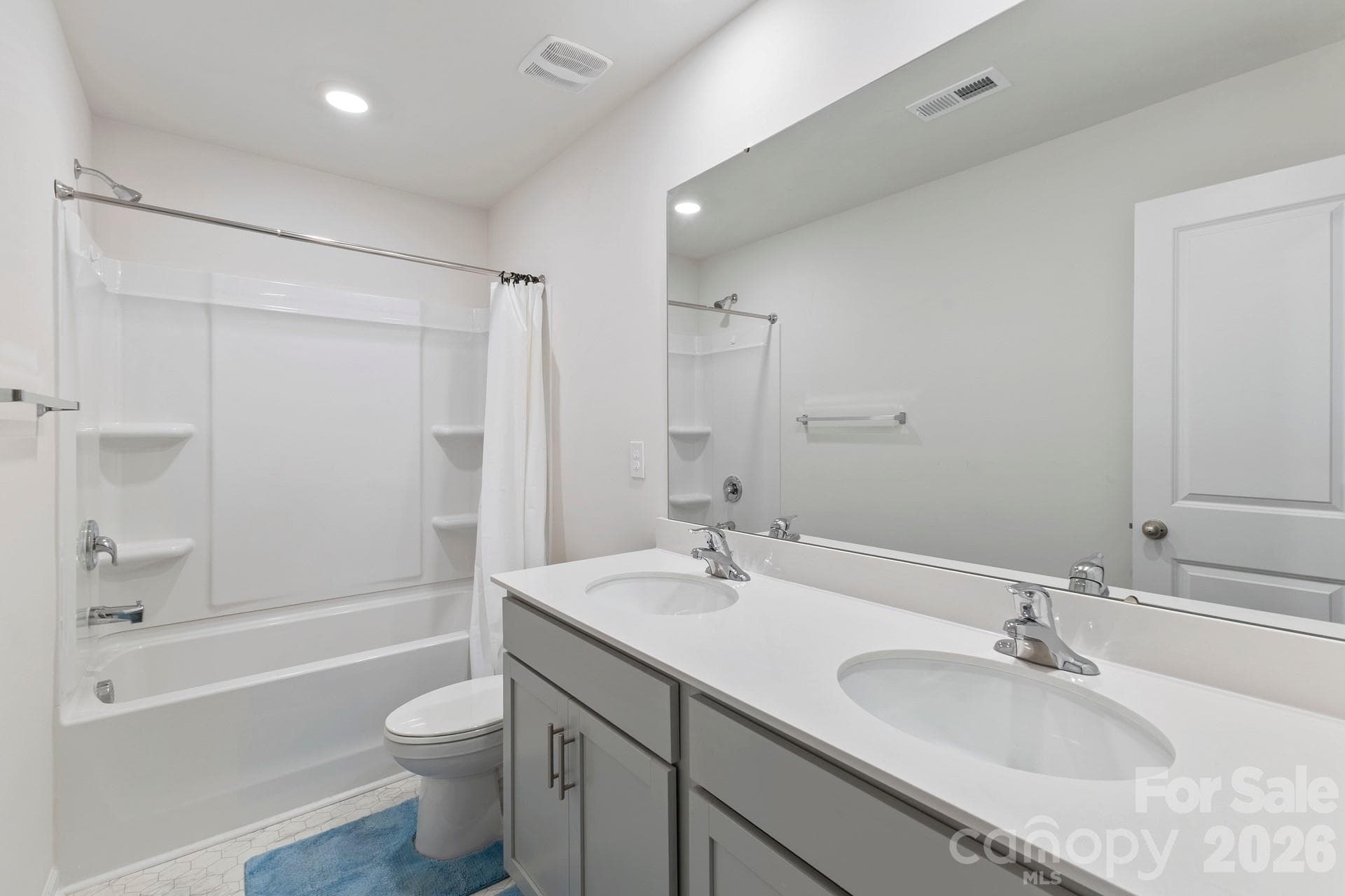 A beautifully designed hall bath comfortably services the secondary bedrooms, featuring a dual-sink vanity and a tub/shower combination. - 3741 Stanley Creek Drive, Mount Holly