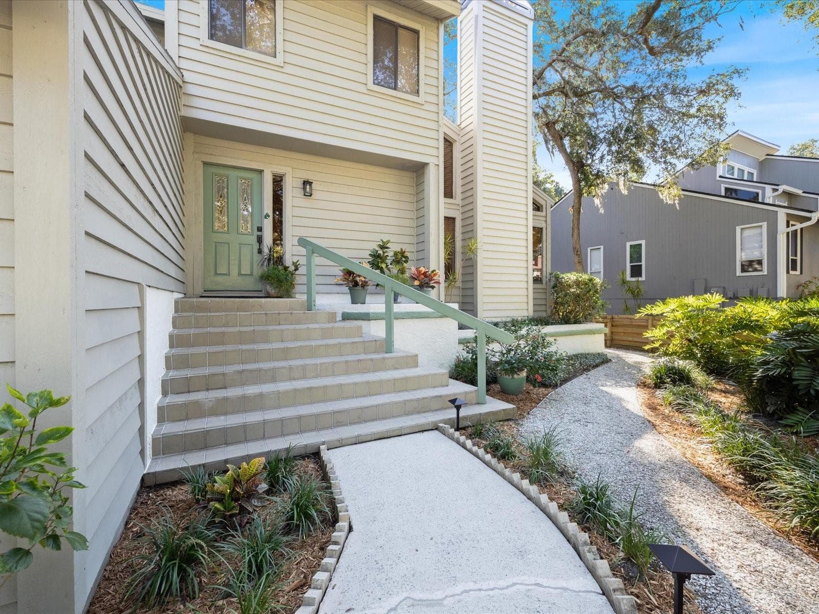 Stairs leading into hom with part of the beautiful zero scaping seen - 3328 BRIARWOOD CIR, SAFETY HARBOR