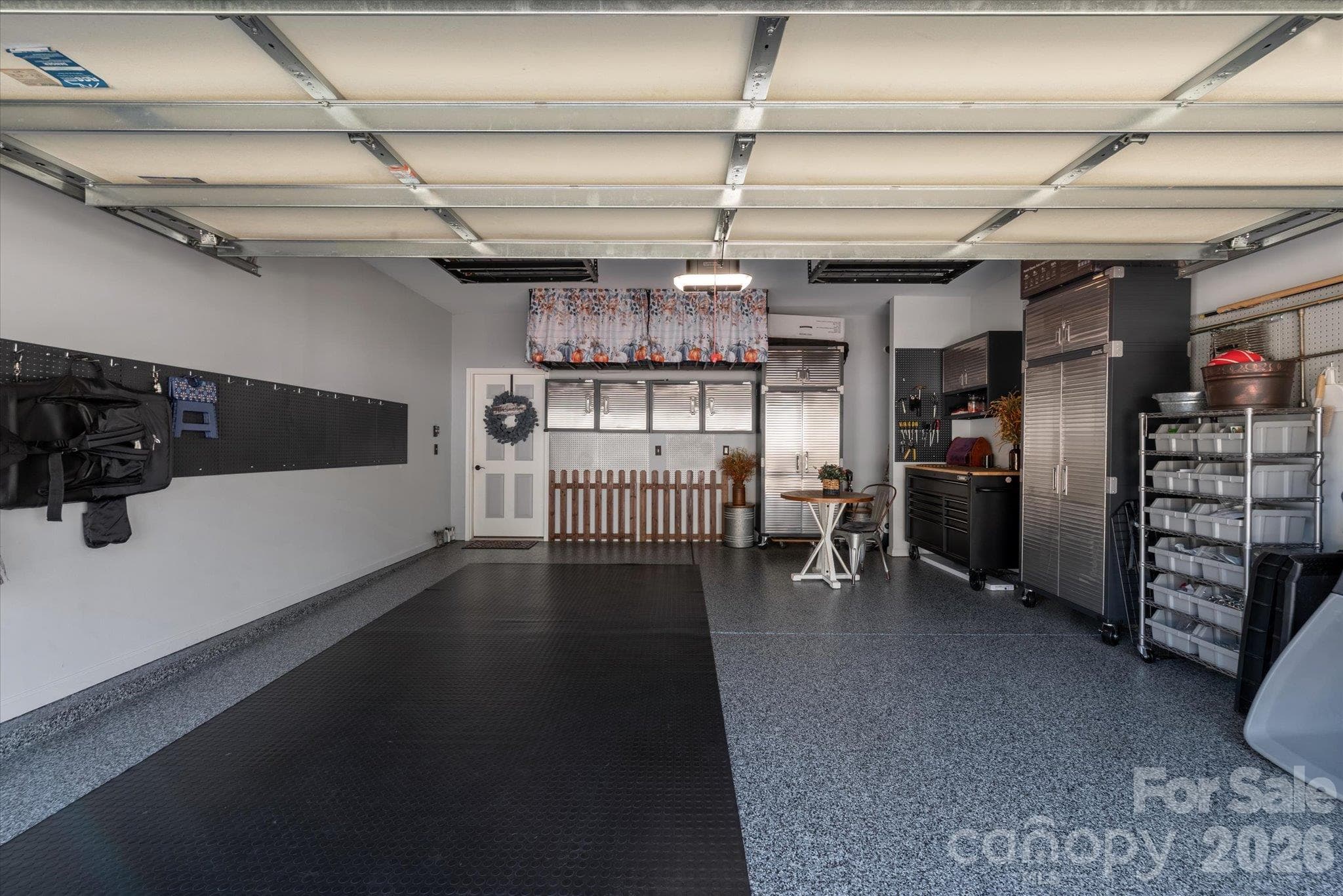 DREAM garage with epoxy floor, overhead storage, mounted stainless steel cabinets, pegboards for organizing, and new garage door system! - 23121 Whimbrel Circle, Indian Land