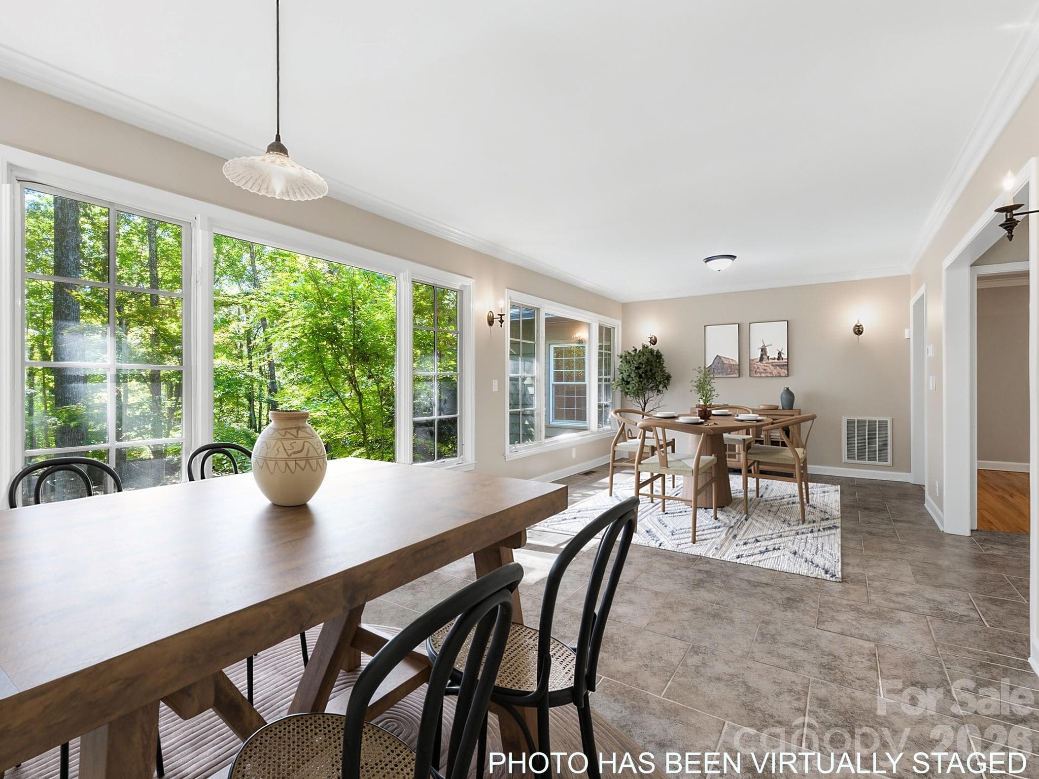 The large room spanning the back of the house can be designated into distinct areas. As shown in this staged photo, there can be a formal dining area in one section and a smaller kitchen table in the area closer to the kitchen. - 175 Mimosa Road, Columbus