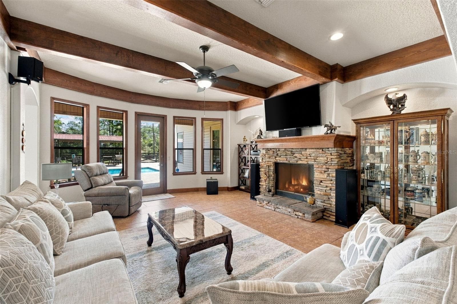 FAMILY ROOM WITH WOOD BEAM CEILING AND GAS FIREPLACE - 10484 GYPSY AVE, WEEKI WACHEE