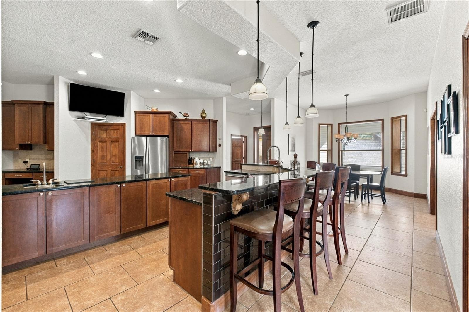 BAR SEATING IN KITCHEN - 10484 GYPSY AVE, WEEKI WACHEE