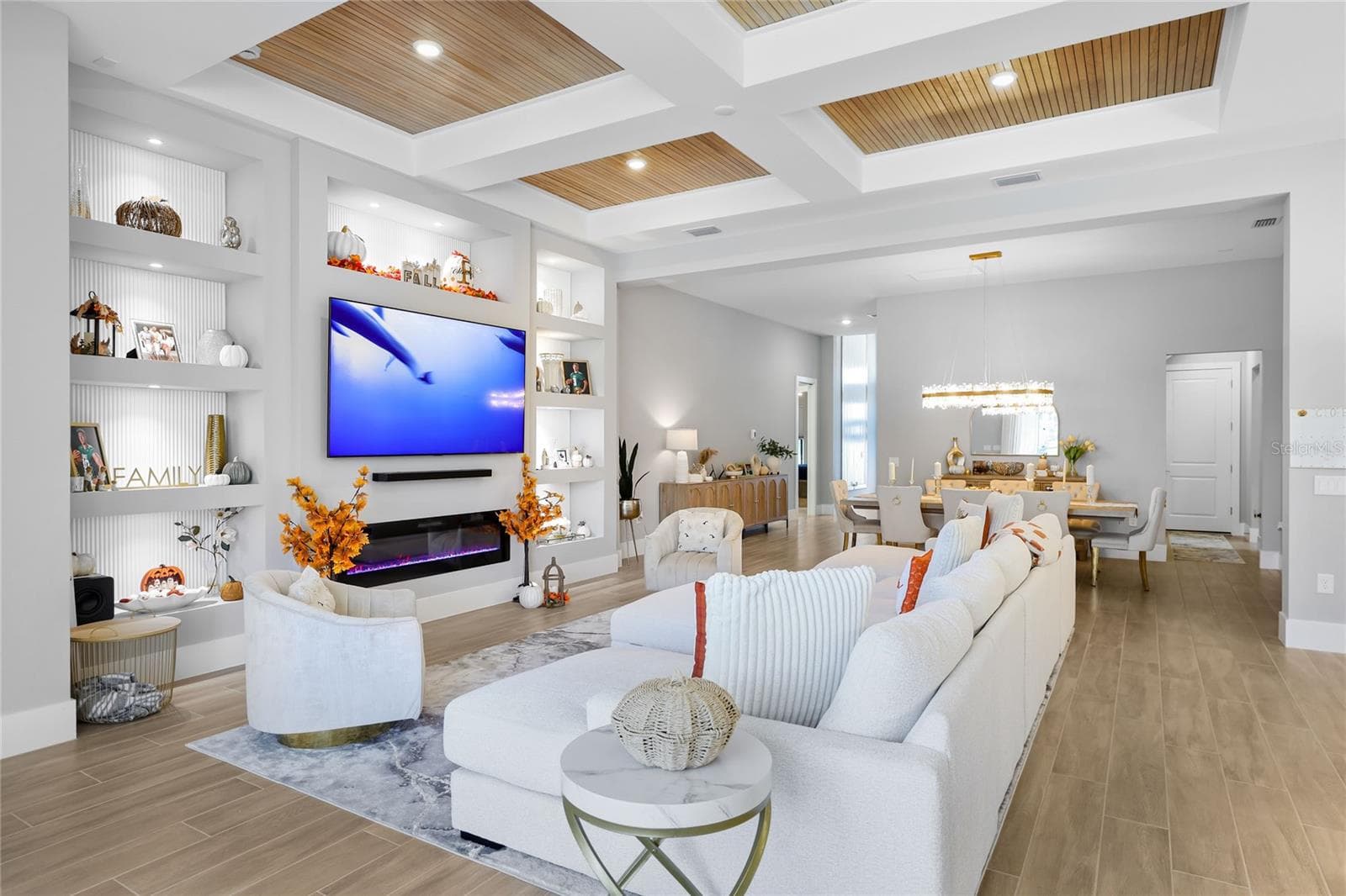 Custom built-in cabinetry with elegant display shelving and a striking fireplace creates a sophisticated focal point in the living room, blending timeless design with warmth and style. - 14726 EAGLE BRANCH DR, NOKOMIS