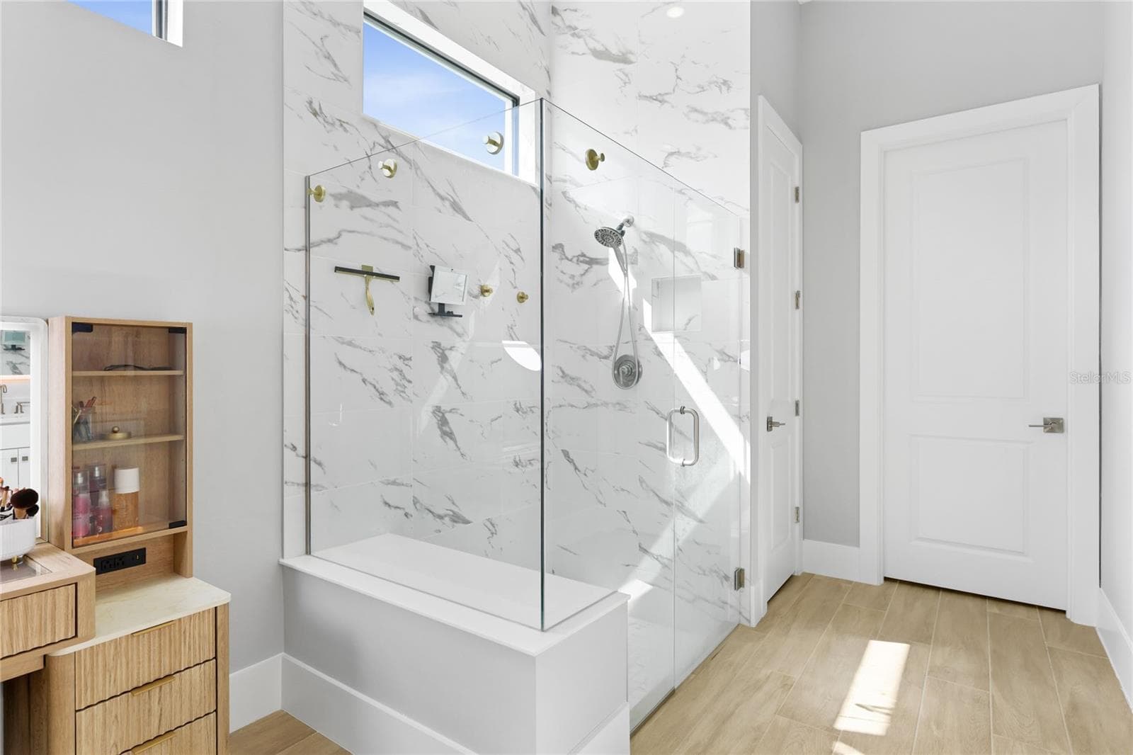 Primary Bathroom with walk in show with full glass enclosure, under lighting cabinetry, illuminating mirrors and expansive walk-in closet with custom shelving and cabinetry. - 14726 EAGLE BRANCH DR, NOKOMIS