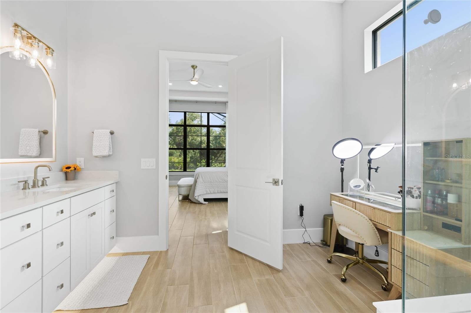 Primary Bathroom with walk in show with full glass enclosure, under lighting cabinetry, illuminating mirrors and expansive walk-in closet with custom shelving and cabinetry. - 14726 EAGLE BRANCH DR, NOKOMIS