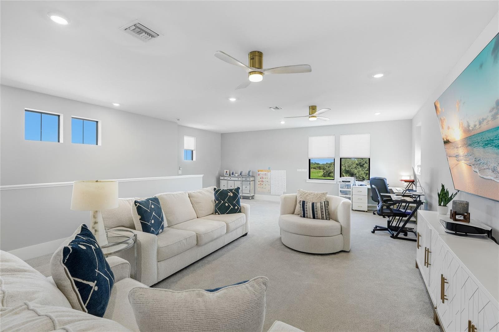 Light-filled bonus room featuring ample windows and transom windows, offering a versatile space ideal for a second TV room, home office, or additional gathering area—perfect for entertaining guests and enjoying quality time with family - 14726 EAGLE BRANCH DR, NOKOMIS