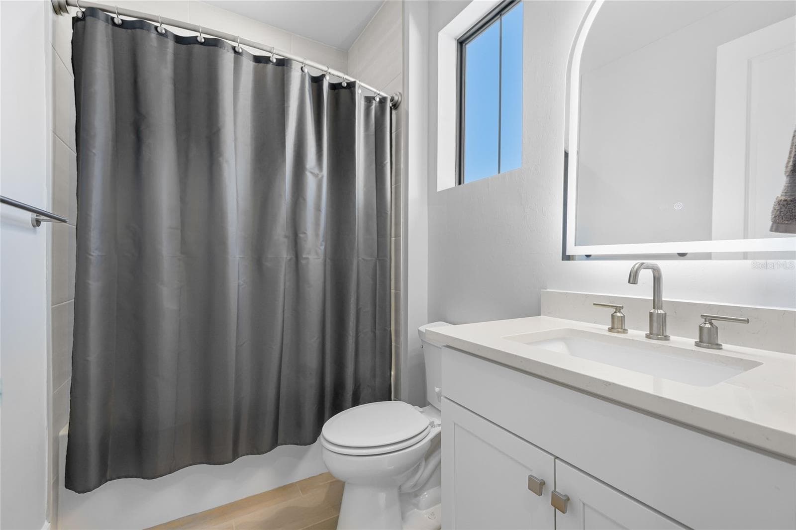 Bathroom 4 with Tub/Shower combination and under lighting cabinetry and illuminating mirror. - 14726 EAGLE BRANCH DR, NOKOMIS