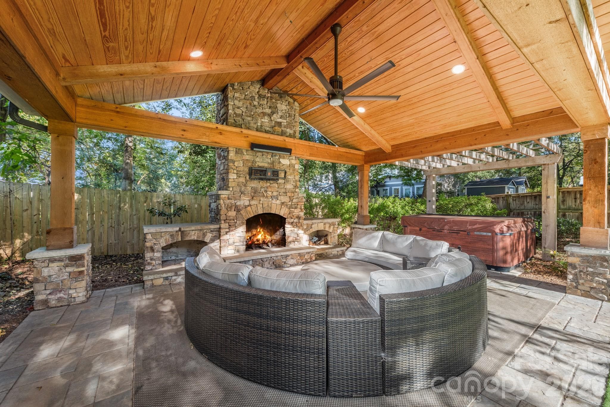 Outdoor space with fireplace, hot tub, and space for a tv. - 3315 Holt Street, Charlotte