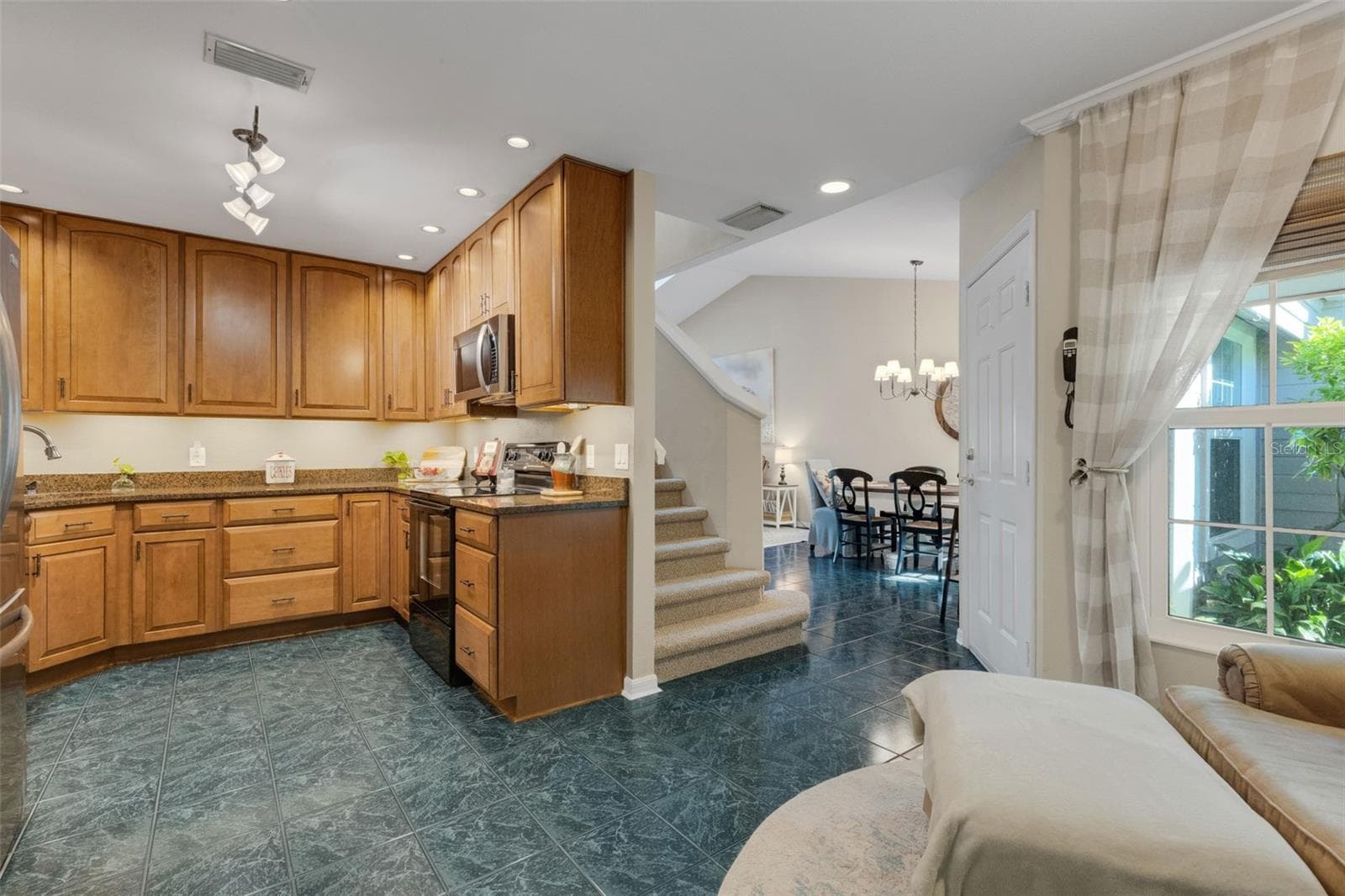 The kitchen boasts wood cabinets and granite countertops. - 1113 WATERFALL LN, LAKELAND