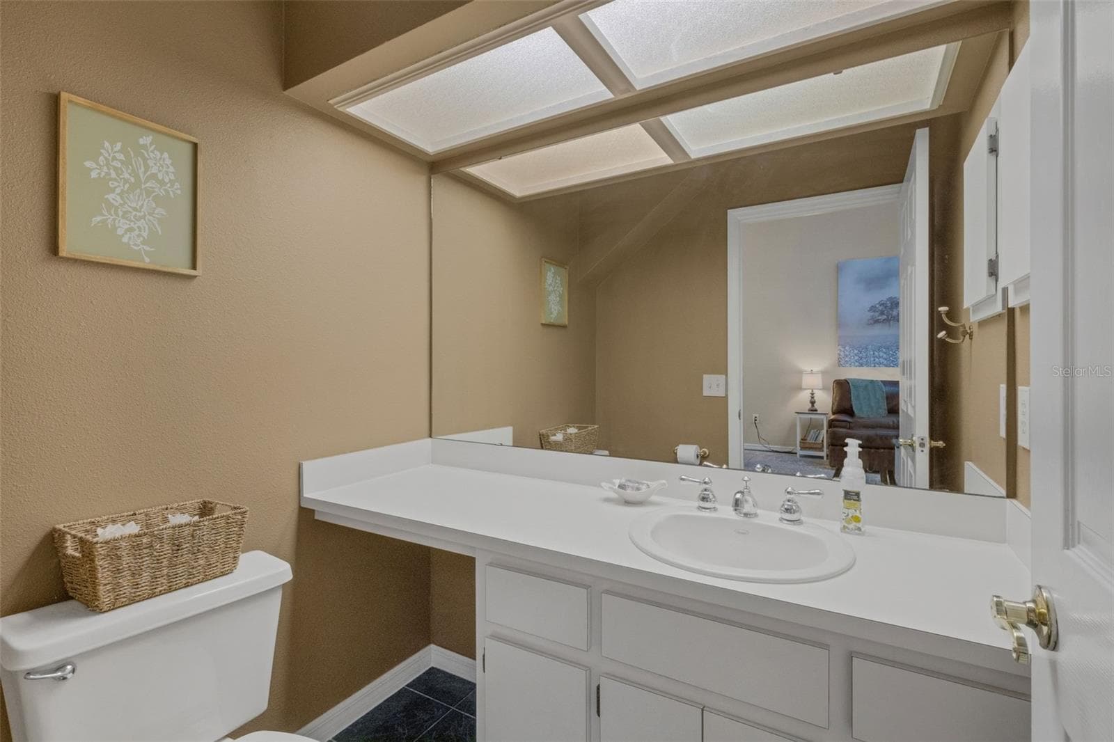 Tucked into an alcove under the stairs is the guest powder room. - 1113 WATERFALL LN, LAKELAND