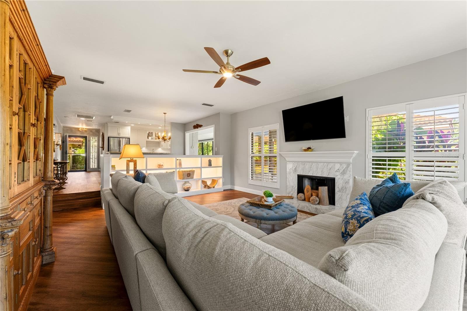 Open-plan living space with wood-burning fireplace and luxury vinyl flooring. - 1720 KESTRAL PARK WAY S #49, SARASOTA