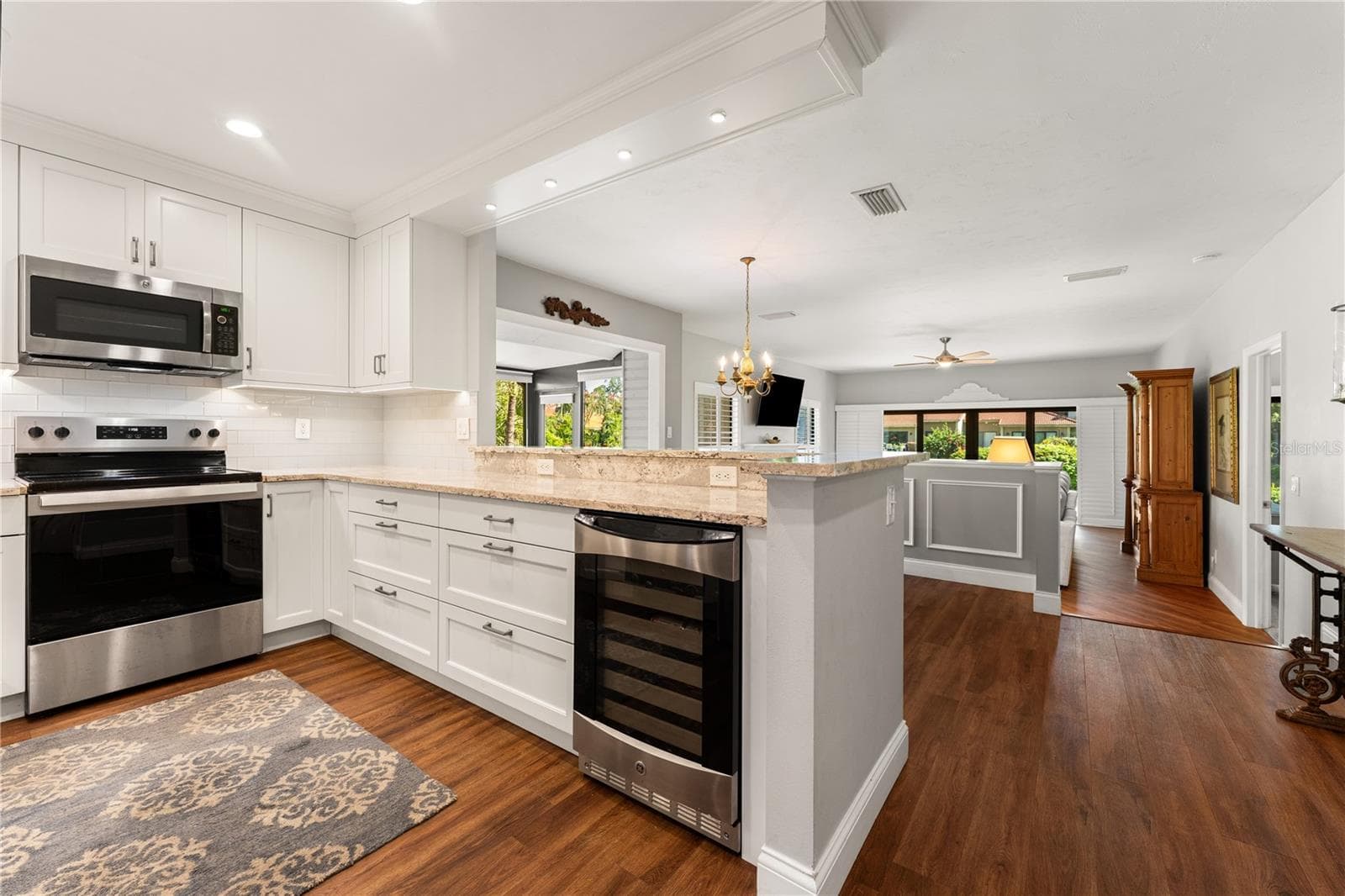 Kitchen equipped with solid surface counters, stainless steel appliances, and wine cooler. - 1720 KESTRAL PARK WAY S #49, SARASOTA