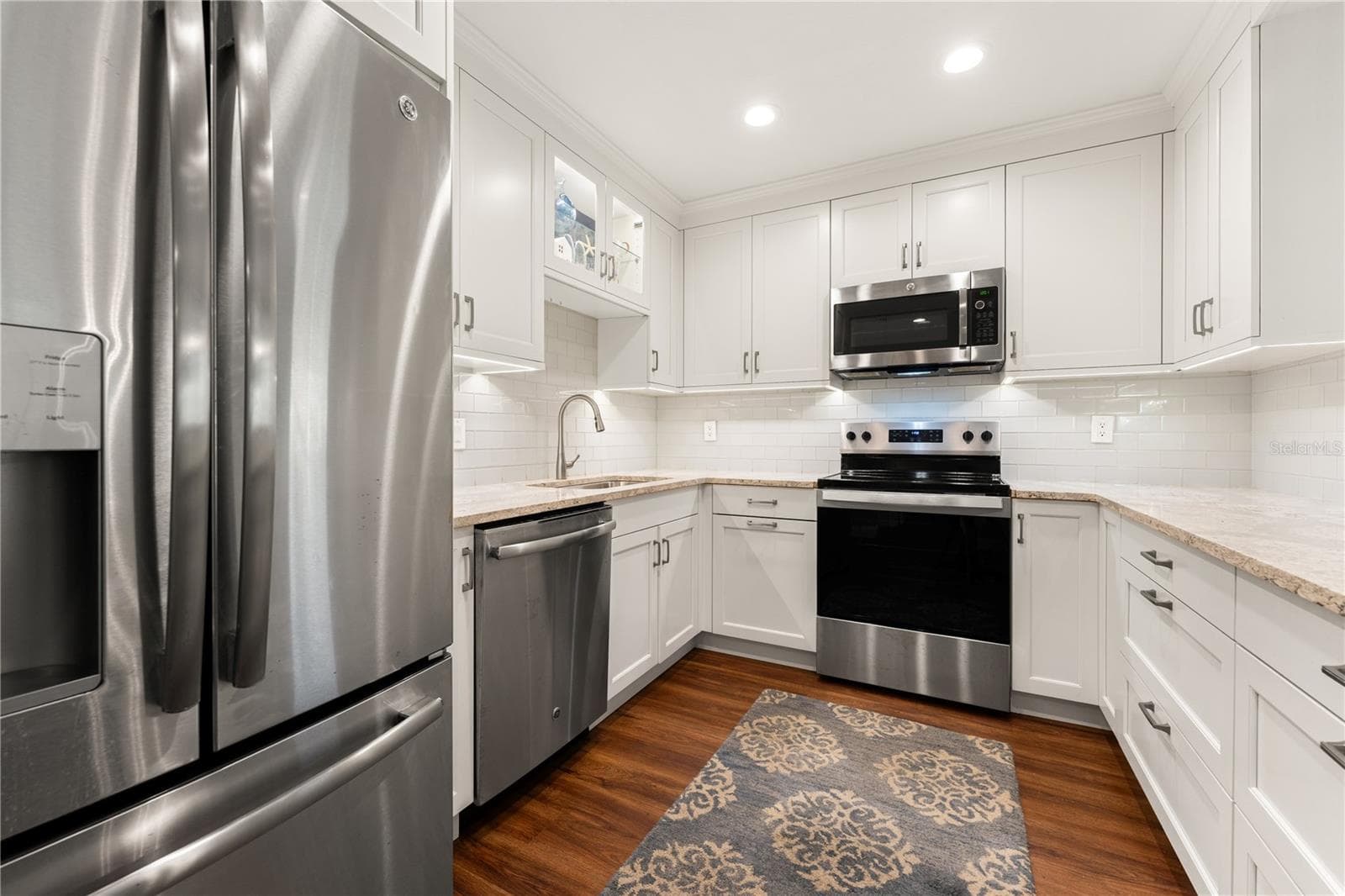 White cabinetry, stainless steel appliances, and quartz and granite counters. - 1720 KESTRAL PARK WAY S #49, SARASOTA