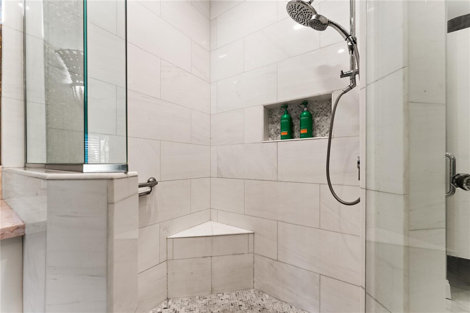 Walk-in shower with custom tile work and built-in bench. - 1720 KESTRAL PARK WAY S #49, SARASOTA