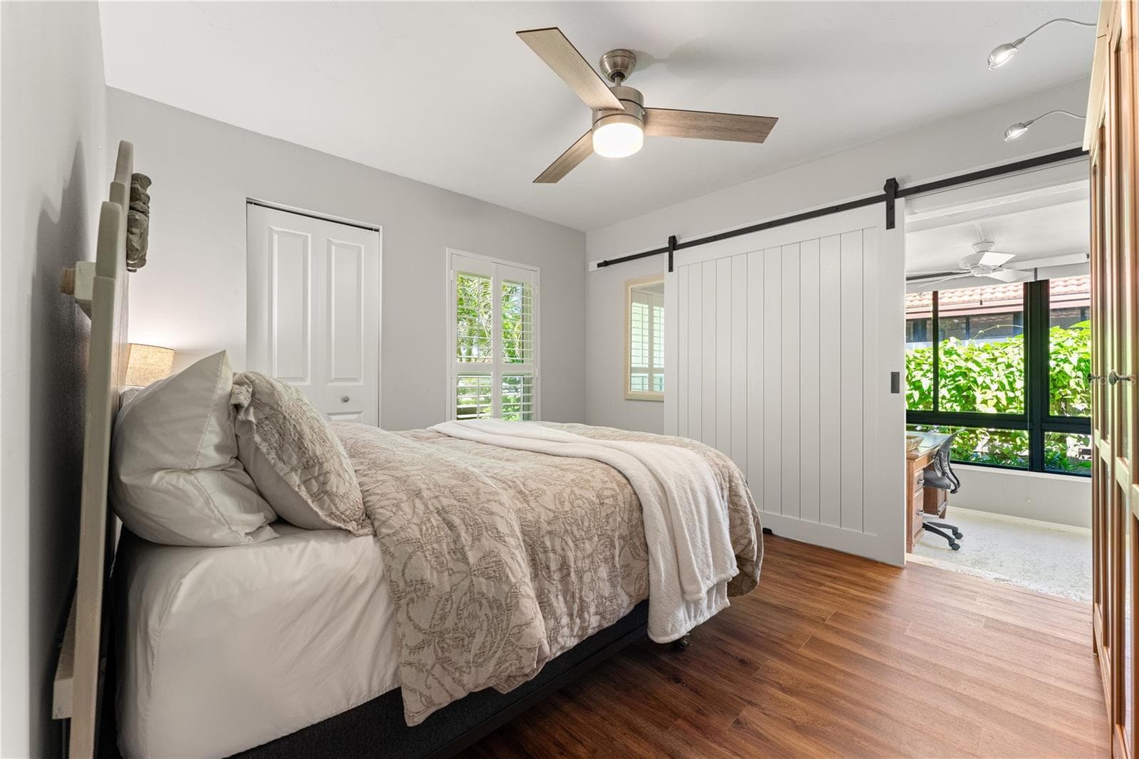 Flexible third bedroom/den featuring a sliding barn door entrence to sunroom. - 1720 KESTRAL PARK WAY S #49, SARASOTA
