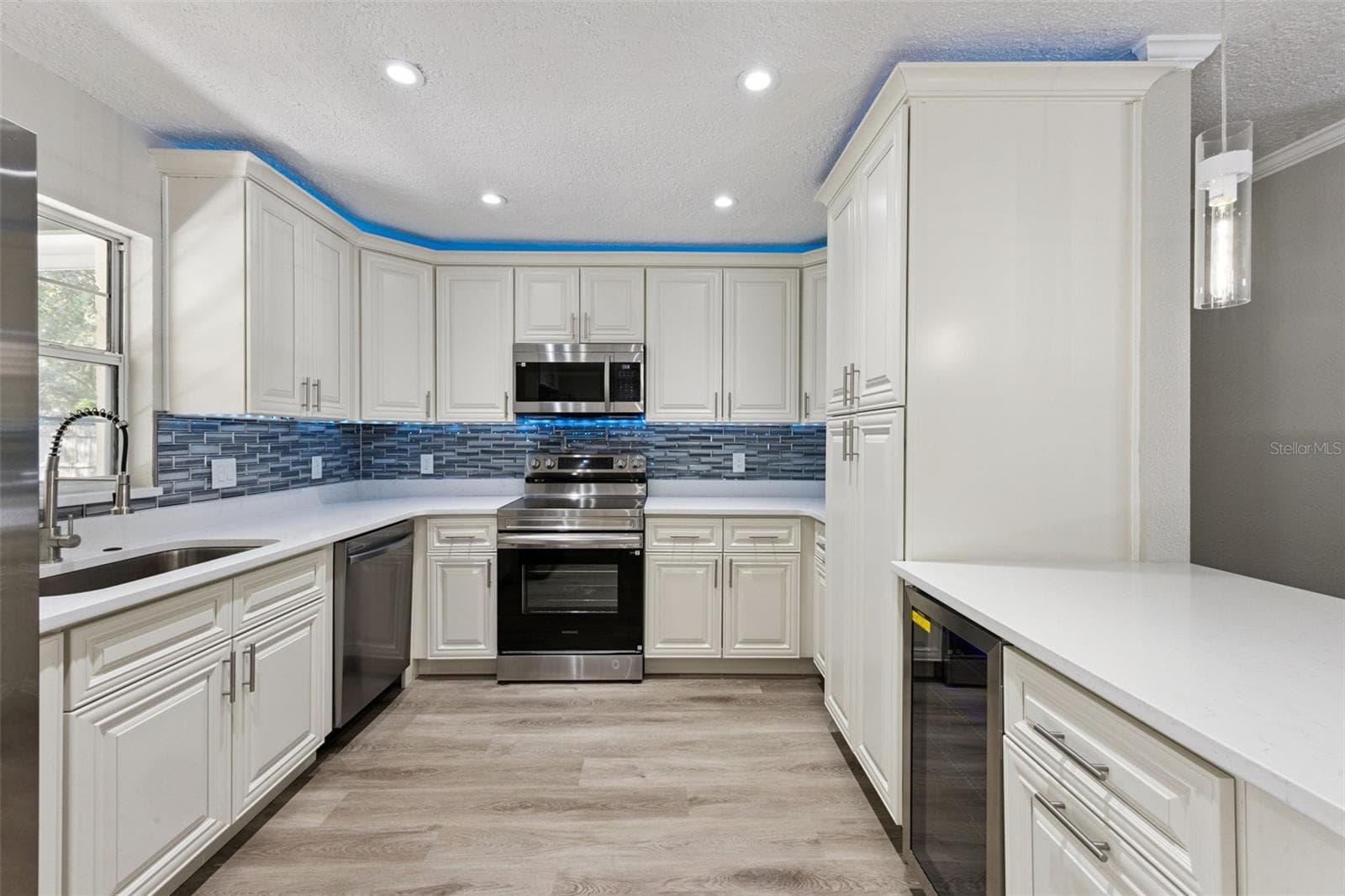 Kitchen Prep & Cooking Zone: Functional kitchen layout with quartz countertops, decorative tile backsplash, electric range, and integrated under-counter wine fridge. - 720 GEORGIA AVE, LONGWOOD