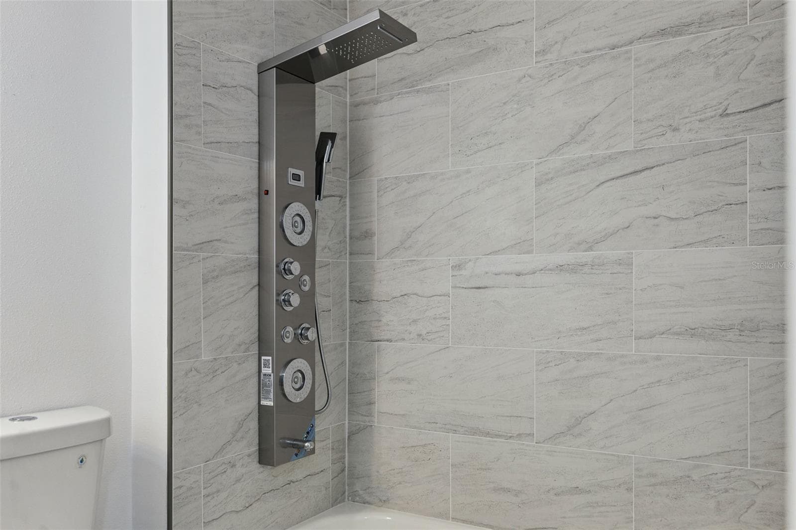 Luxury Shower Panel Detail: Close-up of the stainless steel shower panel featuring a rainfall showerhead, handheld sprayer, and massage body jets - 720 GEORGIA AVE, LONGWOOD