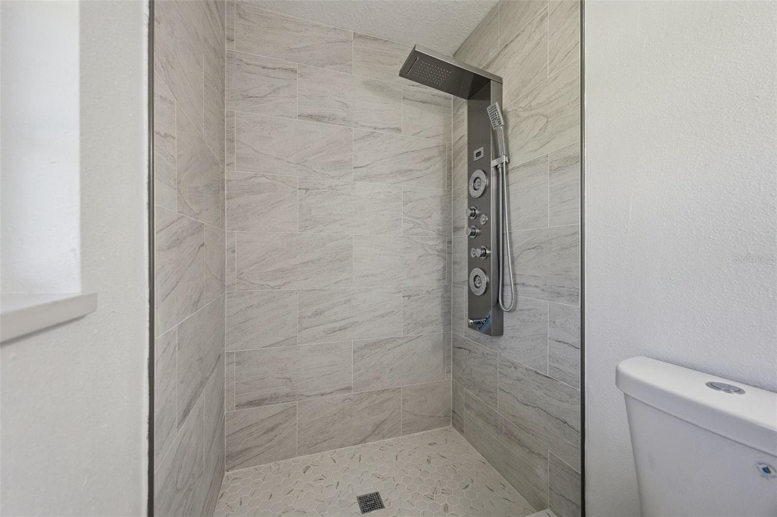 Walk-In Tile Shower: Custom step-in shower with marble-style tile surround, mosaic floor tile, and multi-function shower panel. - 720 GEORGIA AVE, LONGWOOD