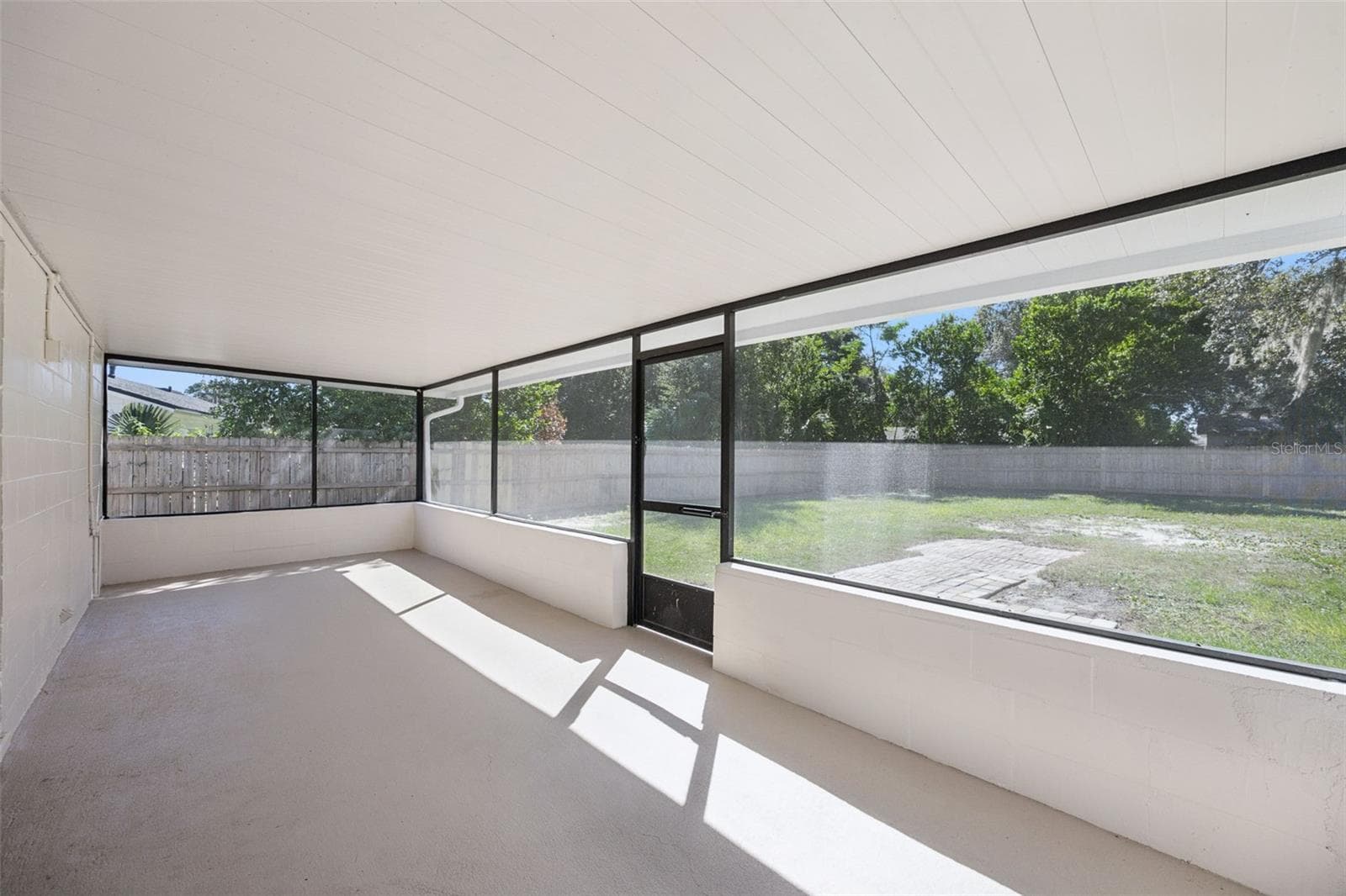 Screened Porch View: Interior view of the screened porch looking out to the expansive fully fenced backyard with screen door lawn access. - 720 GEORGIA AVE, LONGWOOD