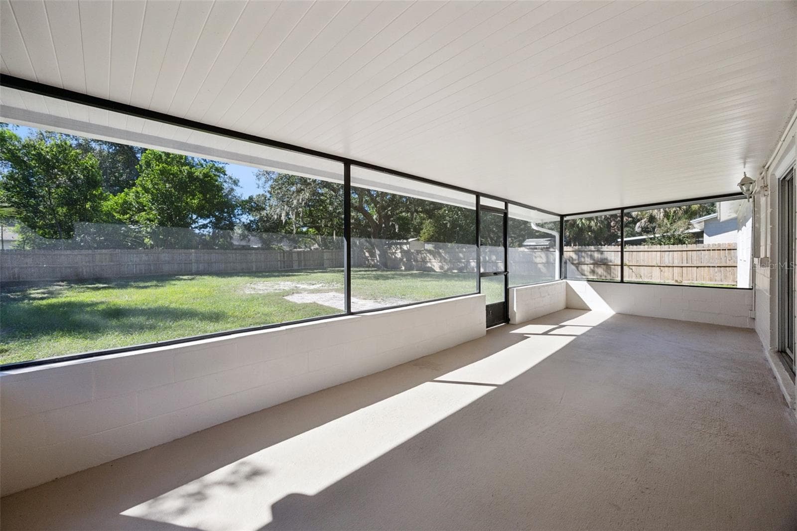 Expansive Lanai Interior: Broad view across the covered screened porch, providing a protected outdoor retreat overlooking the rear grounds - 720 GEORGIA AVE, LONGWOOD