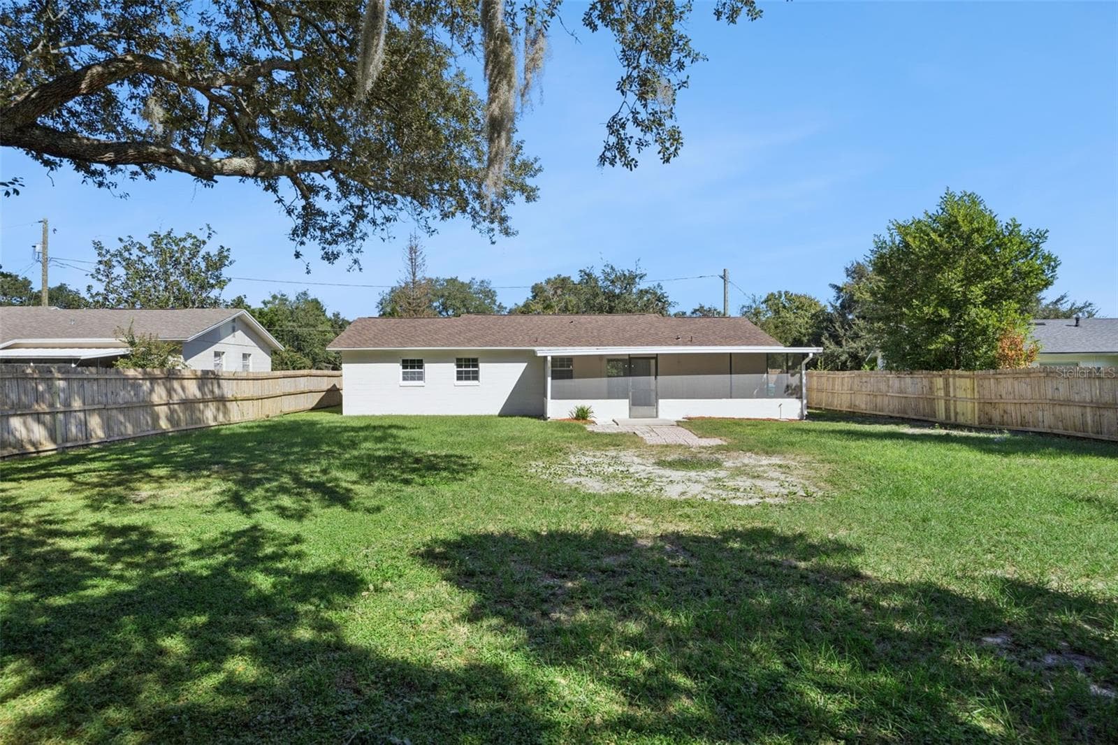 Expansive Backyard: Massive fully fenced backyard framed by majestic mature shade trees, offering ample room for outdoor recreation. - 720 GEORGIA AVE, LONGWOOD