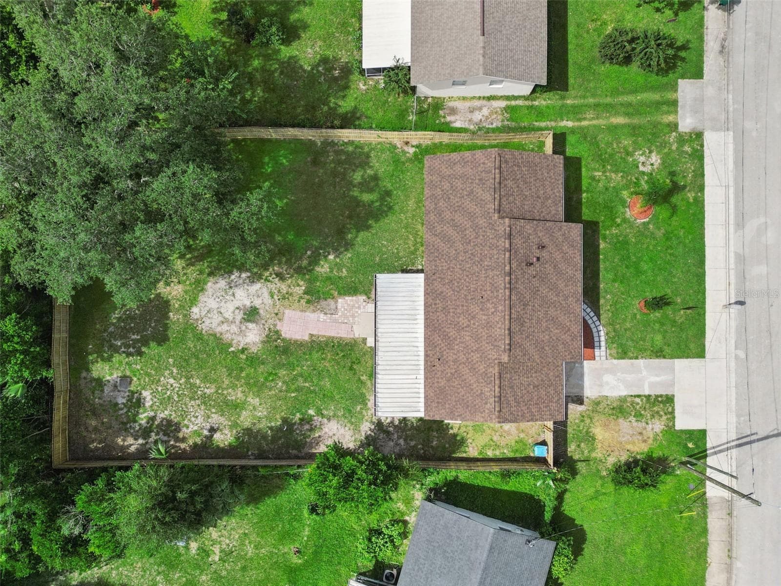 Aerial Overhead View: Direct overhead drone shot displaying the home's roofline, screened porch, driveway, and entire fenced property lot. - 720 GEORGIA AVE, LONGWOOD