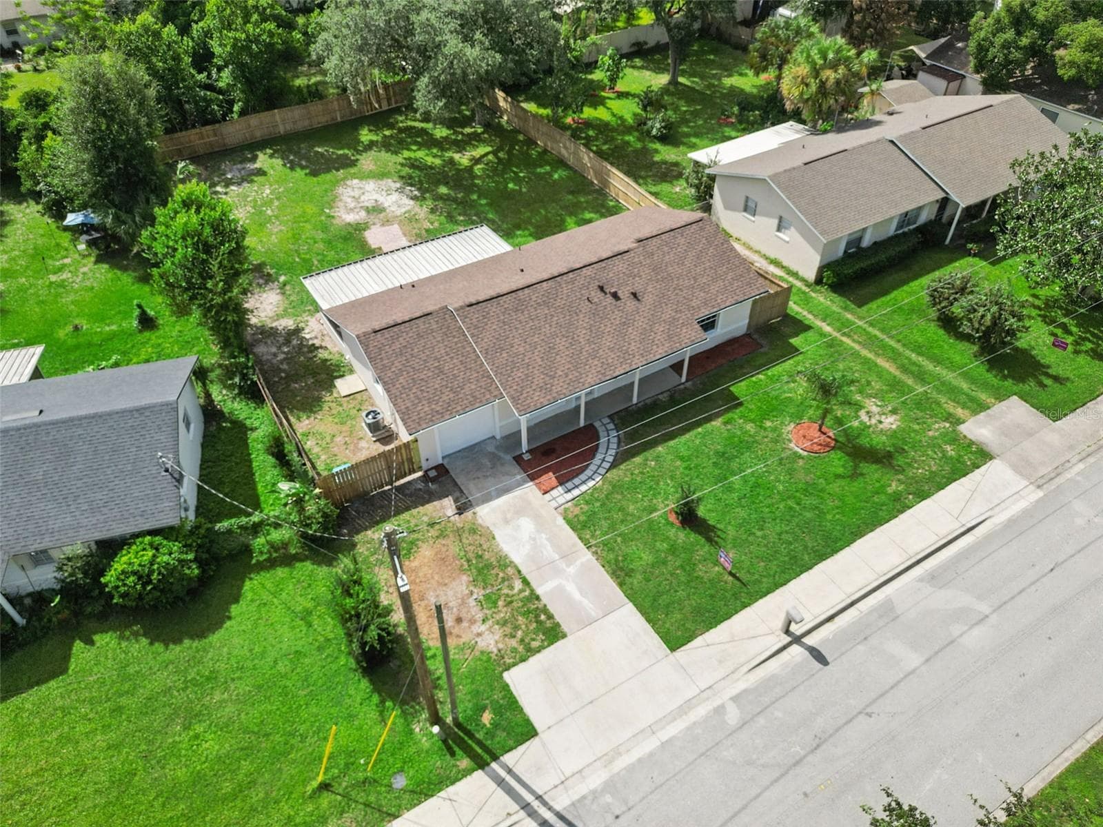 Aerial Front Elevation: High-angle drone perspective showcasing the front lawn, roof, driveway, and quiet residential street. - 720 GEORGIA AVE, LONGWOOD