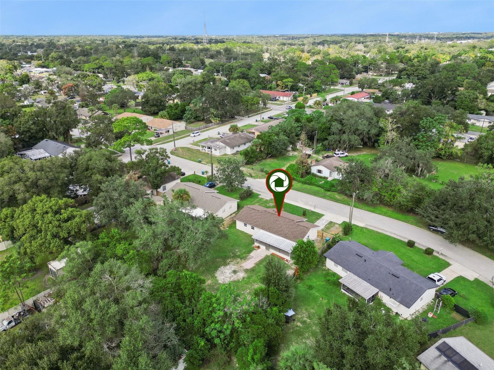 Aerial Neighborhood View: Elevated drone perspective highlighting the property with a location pin set against the surrounding tree-lined community. - 720 GEORGIA AVE, LONGWOOD