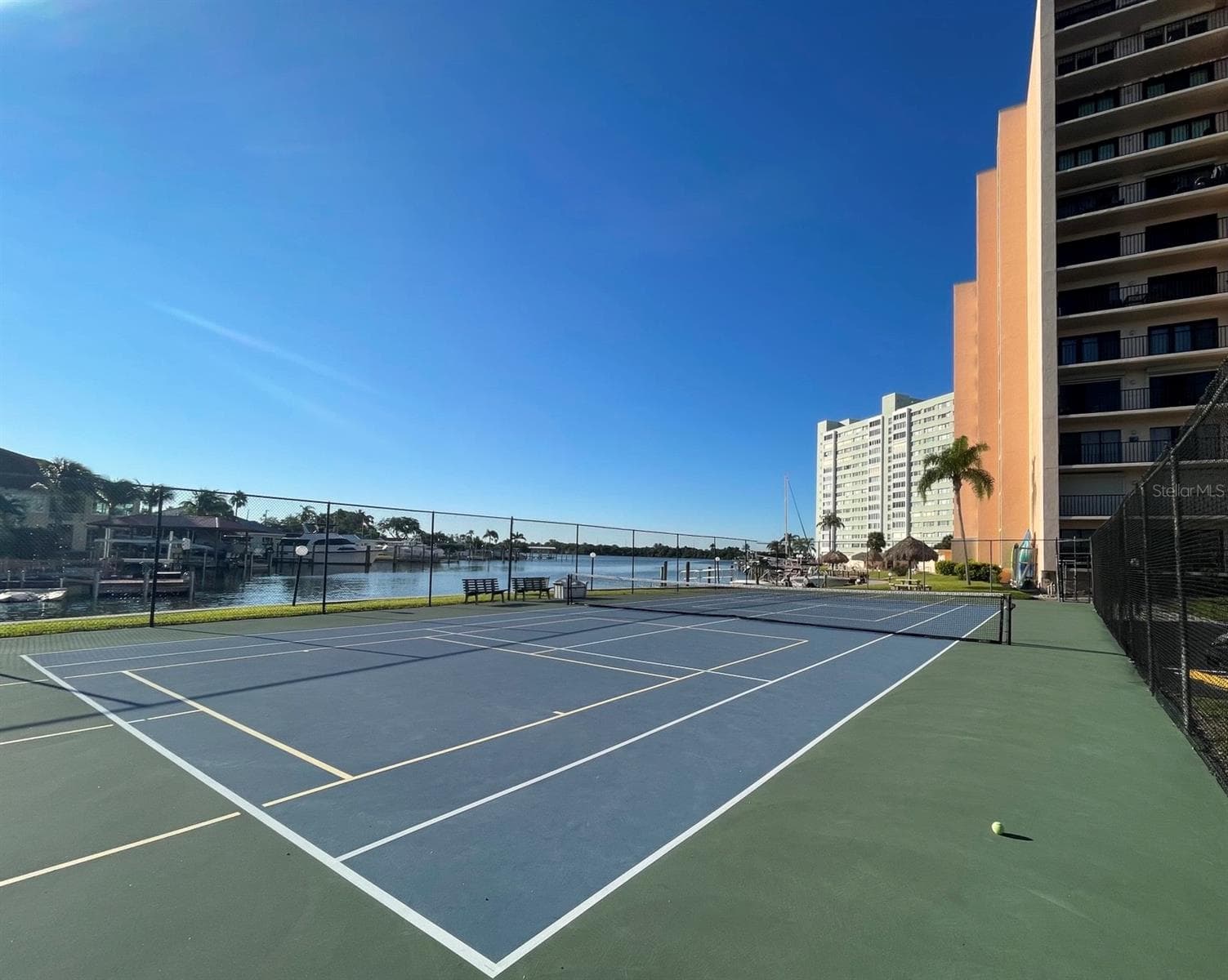 Second angle from tennis court showing the property.  You can expect to play waterfront tennis & pickleball while watching dolphin, manatee, birds & other marine life pass by. - 51 ISLAND WAY #1109, CLEARWATER