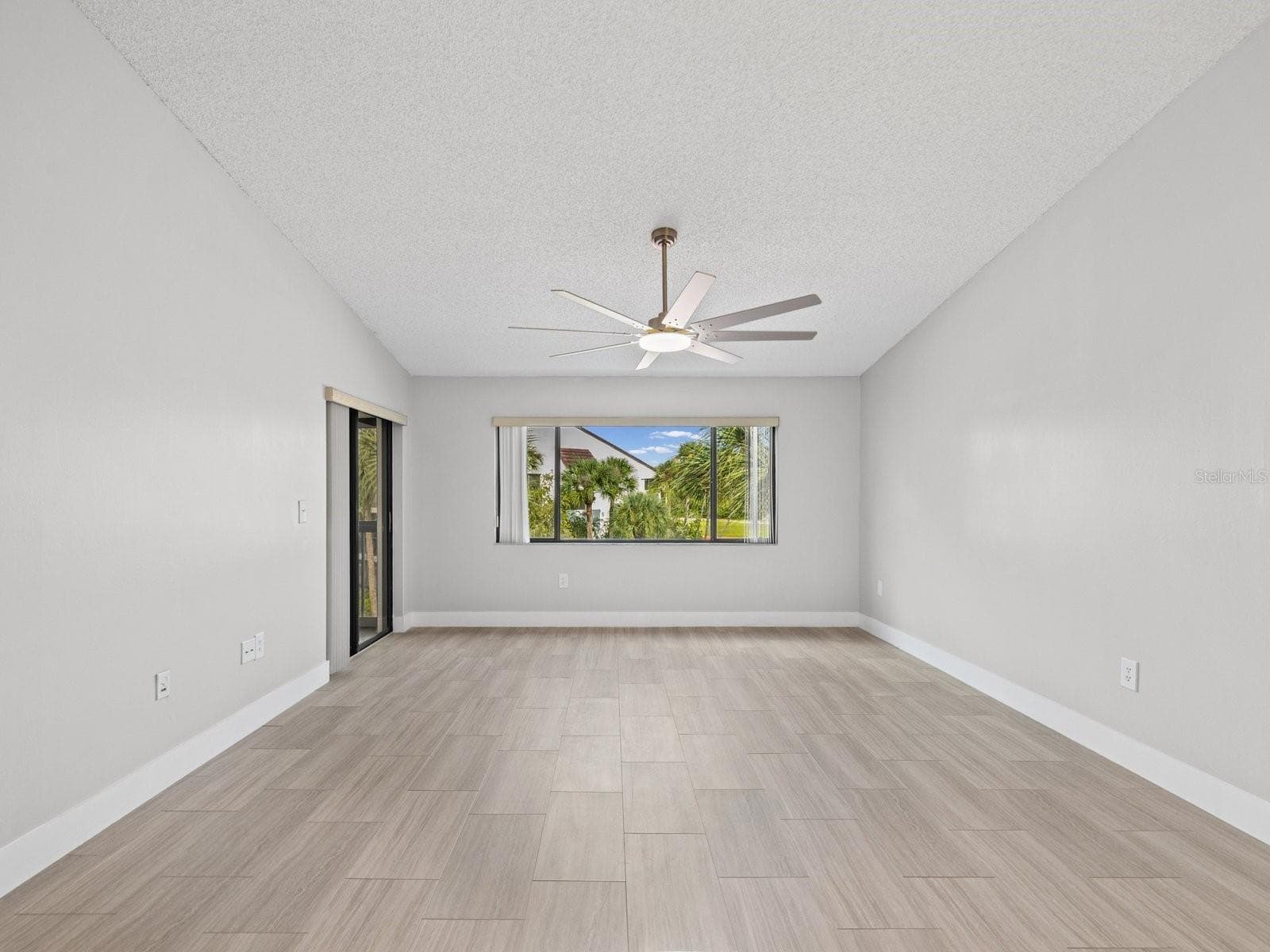 Living room views of palms and screen porch entry on left - 2593 COUNTRYSIDE BLVD #7304, CLEARWATER