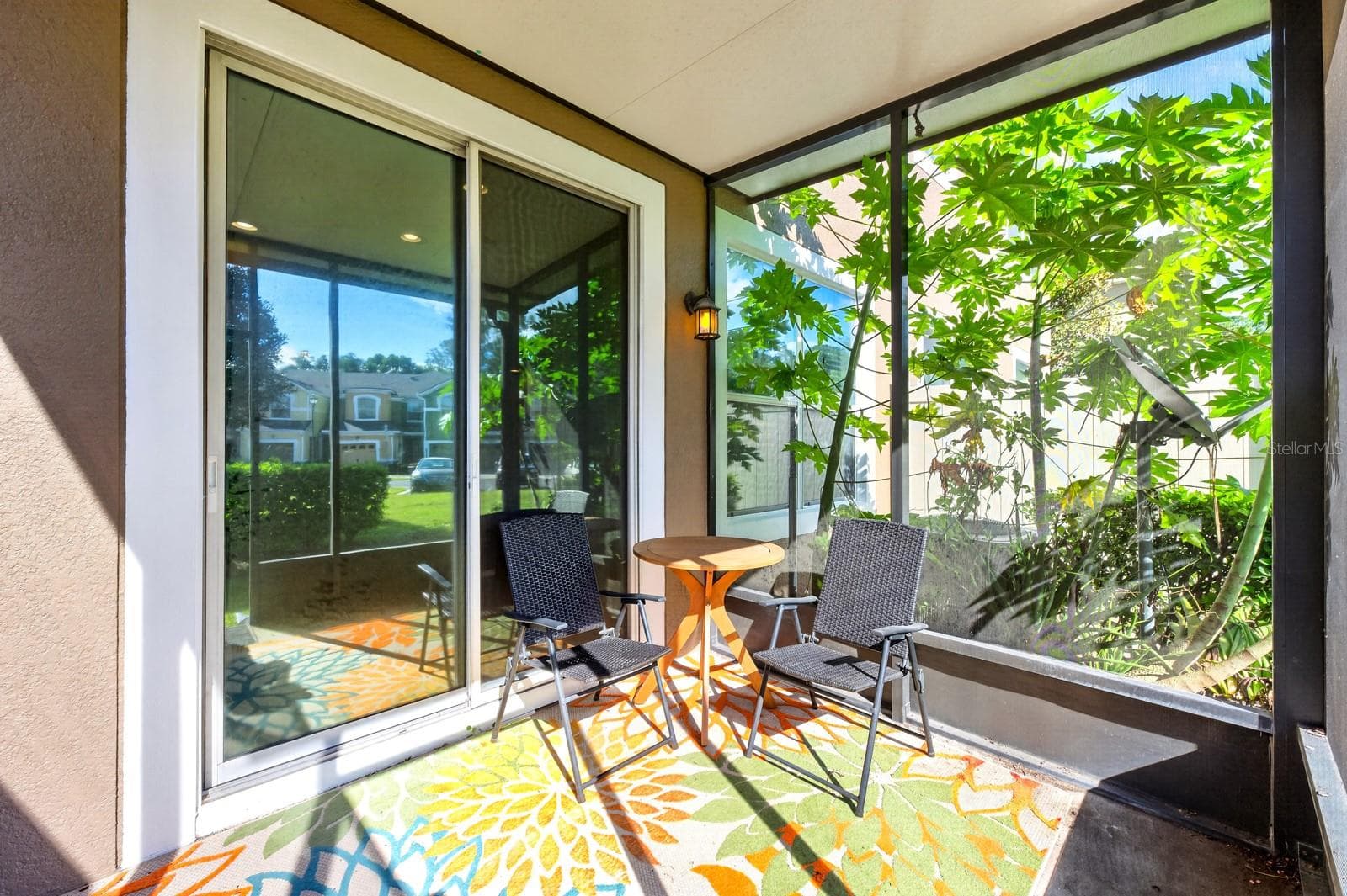 Sliding glass doors extend the living space outdoors to a COVERED, SCREENED REAR PORCH overlooking a peaceful green space. - 2109 VICTORIA GLEN DR, SANFORD