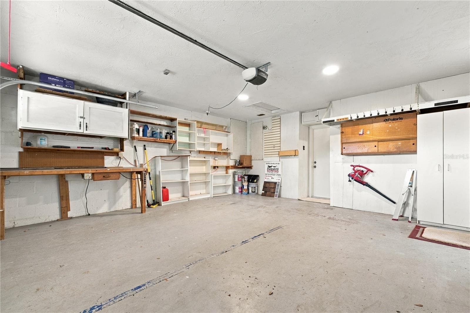 68a. Garage with FRESHLY Painted Ceiling! Plenty of Storage.. 3 of the Bookshelves Shown in Picture Have Been Removed.. Existing Storage is Sturdy & Ready for Your Storage Needs! - 112 PEACOCK CIR, SAFETY HARBOR