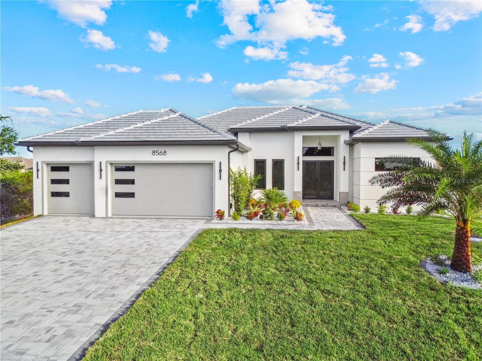 Front Exterior View with Paver Driveway and Landscaping - 8568 SANTA CRUZ DR, PORT CHARLOTTE