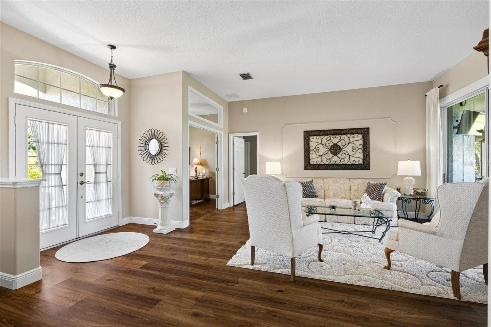 Formal living room overlooking the patio and golf course - 9921 LAUREL VALLEY AVENUE CIR, BRADENTON